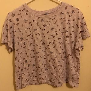 A light purple short sleeve shirt with flowers on it.